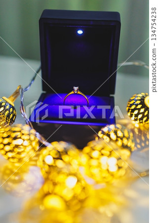An Elegant Engagement Ring Presented in a Beautiful Box Adorned with Decorative Lights 134754238