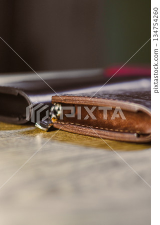Closeup of elegant leather wallets on rustic wood, highlighting exceptional craftsmanship and quality materials that attract fashion enthusiasts, showcasing style and functionality in one product Closeup of elegant leather wallets on rustic wood, highlighting exceptional craftsmanship and quality materials that attract fashion enthusiasts, showcasing style and functionality in one product 134754260