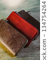 An elegant collection of luxurious leather wallets is arranged on a polished wooden surface, showcasing their exquisite details, quality, and craftsmanship for a captivating effect 134754264