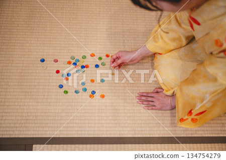 身穿黃色和服、手持彈珠的年輕女子 134754279