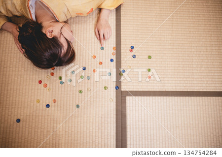 A young woman wearing a yellow kimono and marbles 134754284