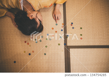 A young woman wearing a yellow kimono and marbles 134754285