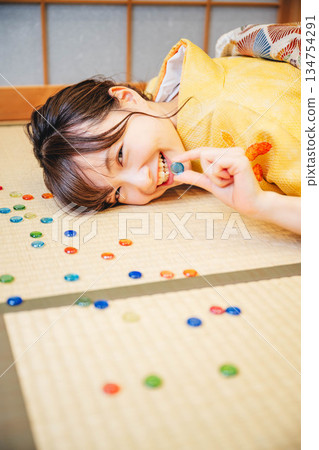 A young woman wearing a yellow kimono and marbles A young woman wearing a yellow kimono and marbles 134754291