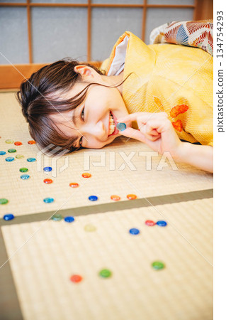 A young woman wearing a yellow kimono and marbles A young woman wearing a yellow kimono and marbles 134754293