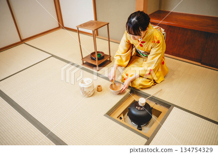 一位年輕貌美的和服女子正在日式房間裡進行茶道表演。 134754329