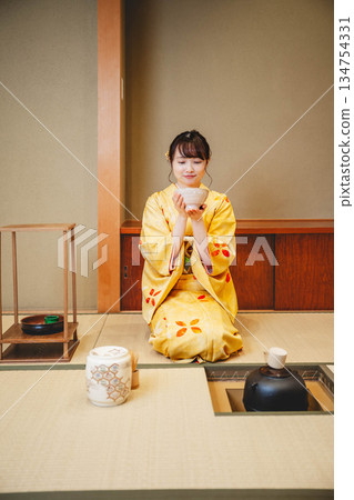 A young and beautiful kimono woman performing a tea ceremony in a Japanese-style room 134754331