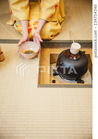 一位年輕貌美的和服女子正在日式房間裡進行茶道表演。 134754340