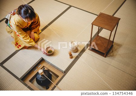 一位年輕貌美的和服女子正在日式房間裡進行茶道表演。 134754346