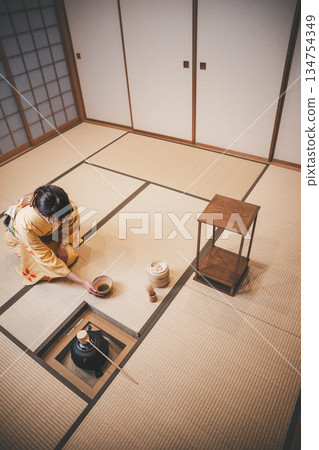 一位年輕貌美的和服女子正在日式房間裡進行茶道表演。 134754349