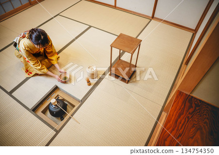 一位年輕貌美的和服女子正在日式房間裡進行茶道表演。 134754350