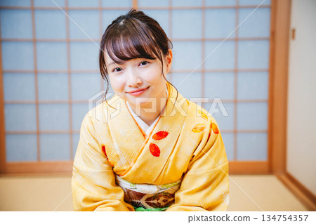 一位年輕貌美的和服女子正在日式房間裡進行茶道表演。 134754357