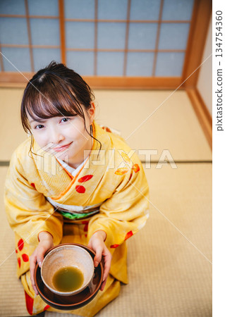 一位年輕貌美的和服女子正在日式房間裡進行茶道表演。 134754360