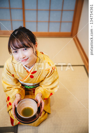 一位年輕貌美的和服女子正在日式房間裡進行茶道表演。 134754361