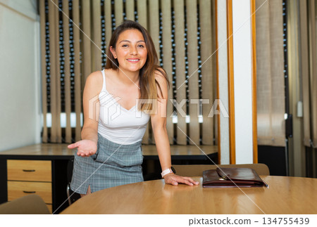 Portrait of woman holding briefcase in hands in modern office 134755439
