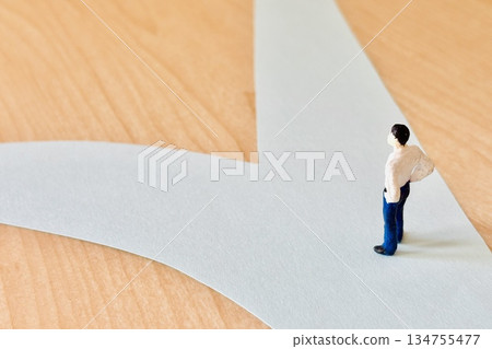 一位商人憂心忡忡地站在十字路口 一位商人憂心忡忡地站在十字路口 134755477