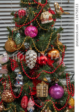 Colorful Christmas Tree With Ornaments, Beads, Gifts, Red Balls, and Sparkling Gold Decorations 134756513