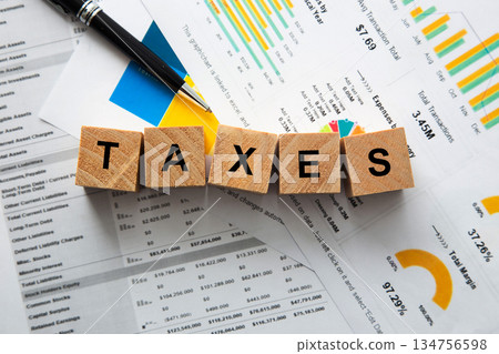 Taxes word on wooden blocks with financial documents 134756598