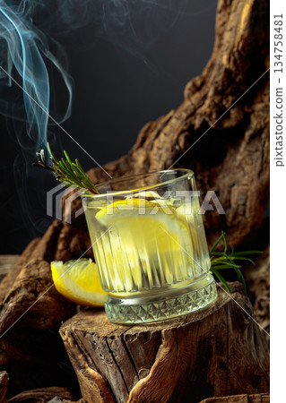 Cocktail gin and tonic with lemon slices and sprig of rosemary. 134758481