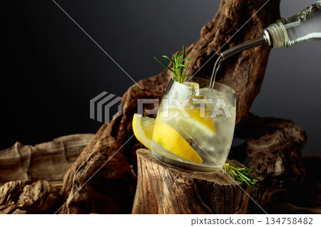 Cocktail gin and tonic with lemon slices and sprig of rosemary. 134758482