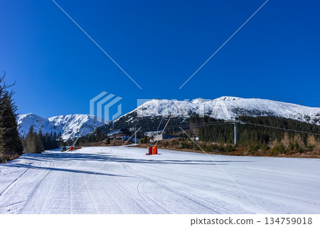 Empty groomed ski slope under a clear blue sky in the mountains. Empty groomed ski slope under a clear blue sky in the mountains. 134759018
