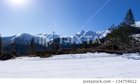Empty groomed ski slope under a clear blue sky in the mountains. Empty groomed ski slope under a clear blue sky in the mountains. 134759022