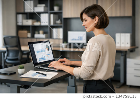一位女士在站立式辦公桌前進行分析 134759113