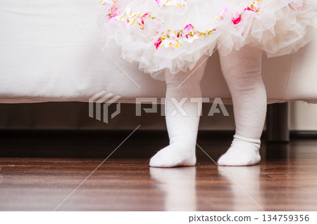 Feet of baby girl in dress 134759356
