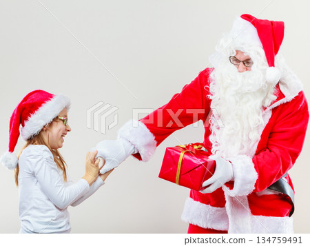 Santa Claus fighting with girl for present 134759491