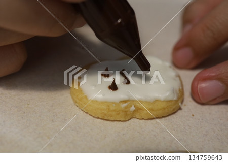 Close-up of creating icing cookies with chocolate faces 134759643