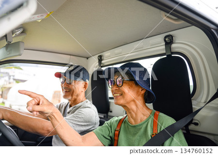 一對老年夫婦指著一輛輕型卡車裡的人。 134760152