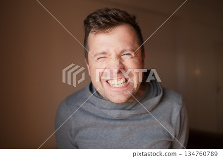 Middle Aged European Man with a Wide Fake Smile, Emotional Portrait 134760789