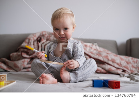 Little Toddler Girl Sitting on Bed Playing with Toys Independently 134760794