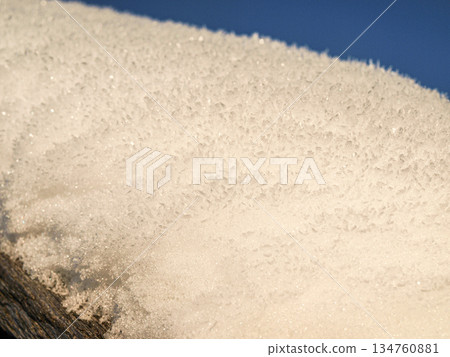 A cap of snow on the roof, the texture of a snowdrift in the sun. 134760881