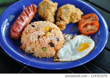 stir fried rice or fried rice with sunny side up egg , fried chicken and sausage stir fried rice or fried rice with sunny side up egg , fried chicken and sausage 134761070
