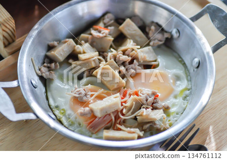 Pan fried eggs with toppings , Skillet Egg or fried egg with sausage and minced pork topping 134761112