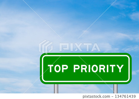 Green color transportation sign with word top priority on blue sky with white cloud background Green color transportation sign with word top priority on blue sky with white cloud background 134761439