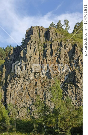 A stunning view of a rugged cliff face adorned with trees, offering a captivating scene for travel, tourism, or environmental projects. It provides an excellent backdrop for adventure-themed content. A stunning view of a rugged cliff face adorned with trees, offering a captivating scene for travel, tourism, or environmental projects. It provides an excellent backdrop for adventure-themed content. 134761611