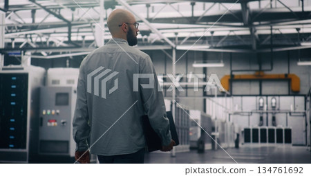 Bearded Engineer Walks Between Rows of Servers, Seemingly Conducting Silent Technical Audit 134761692