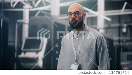 IT Professional Inspecting Rows of Active Server Racks 134761764