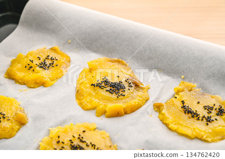 Spread butter on the pressed sweet potato and top with sesame seeds 134762420