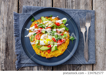 potato rosti topped with poached egg, avocado 134762577