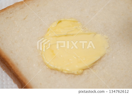圖片展示了在麵包上塗抹人造奶油的過程 圖片展示了在麵包上塗抹人造奶油的過程 134762612