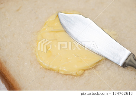圖片展示了在麵包上塗抹人造奶油的過程 圖片展示了在麵包上塗抹人造奶油的過程 134762613
