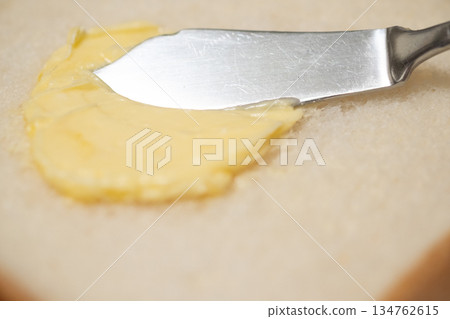 圖片展示了在麵包上塗抹人造奶油的過程 圖片展示了在麵包上塗抹人造奶油的過程 134762615
