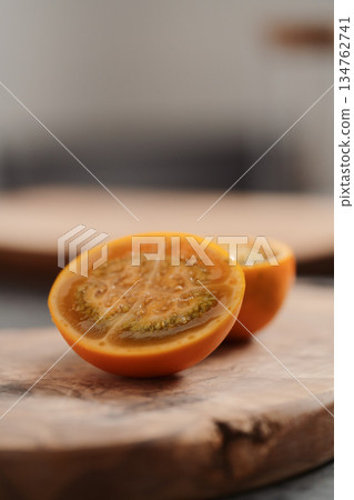 Lulo fruit sliced in halves on olive wood board on kitchen countertop Lulo fruit sliced in halves on olive wood board on kitchen countertop 134762741
