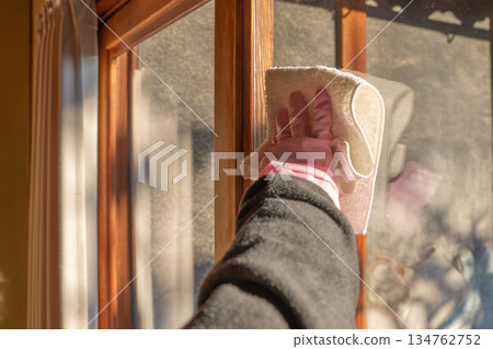 戴著橡膠手套的手正在擦拭窗戶 戴著橡膠手套的手正在擦拭窗戶 134762752