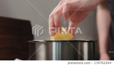 man hand put fettuccine pasta in saucepan with boiling water 134762844