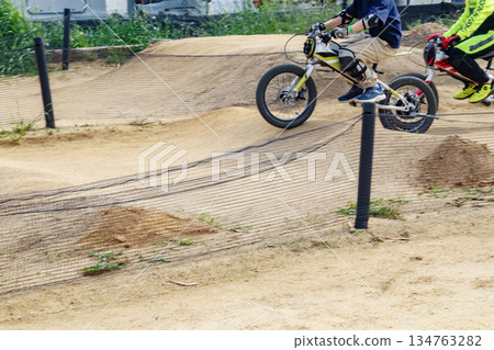 A boy (8 years old) riding a bicycle on a motocross dirt course 134763282