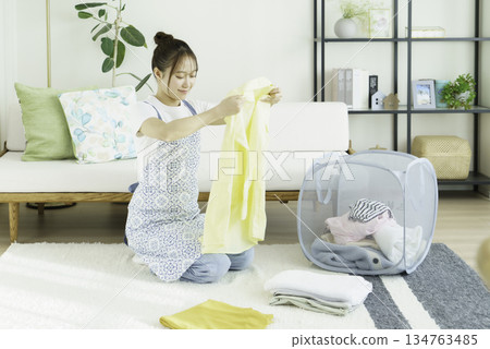 年輕女子在客廳裡疊衣服 134763485