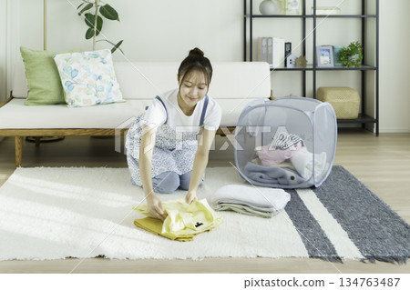 年輕女子在客廳裡疊衣服 134763487